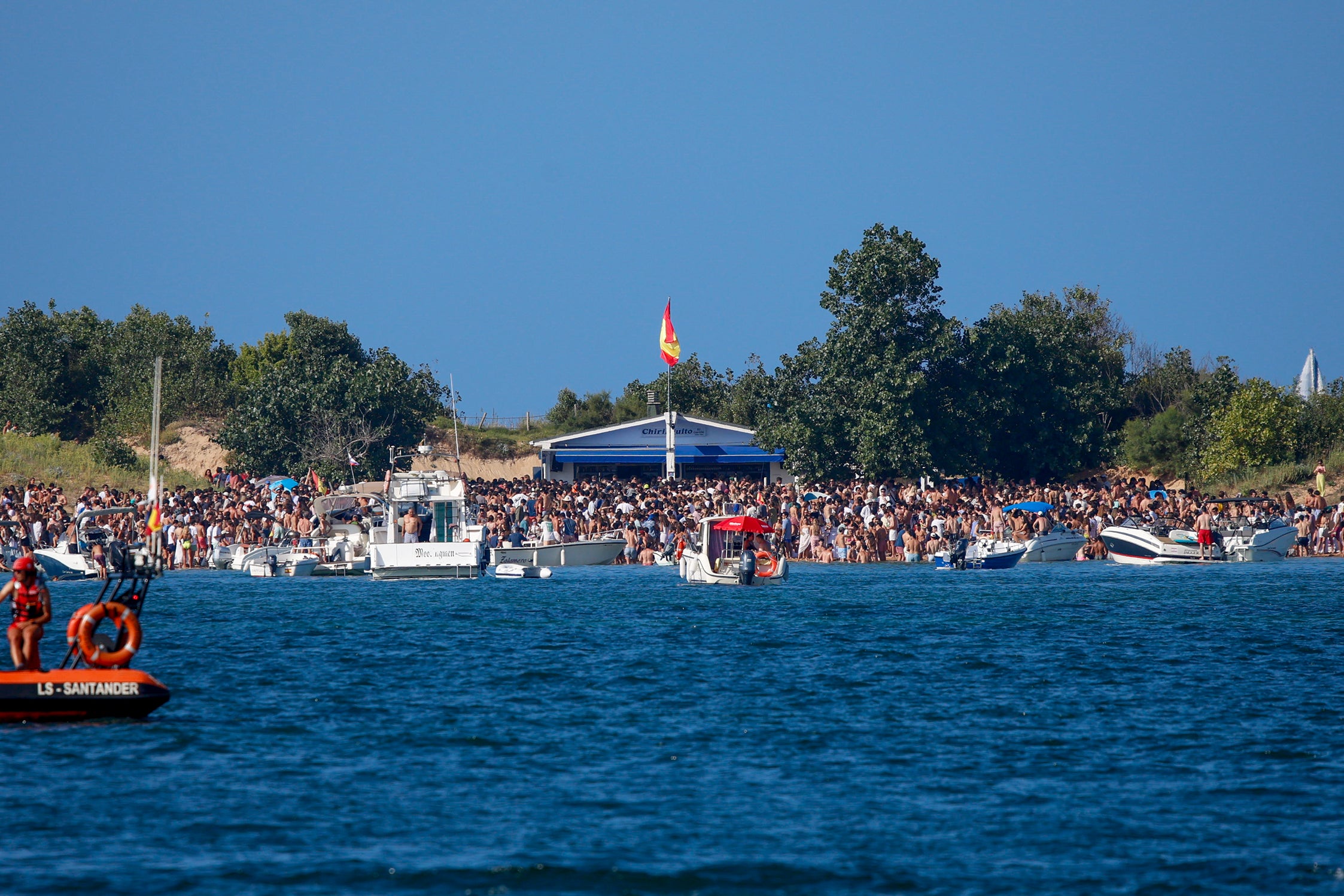 Panorámica que ofrece El Puntal, con multitud de jóvenes y barcos atracados próximos a la orilla, este sábado.