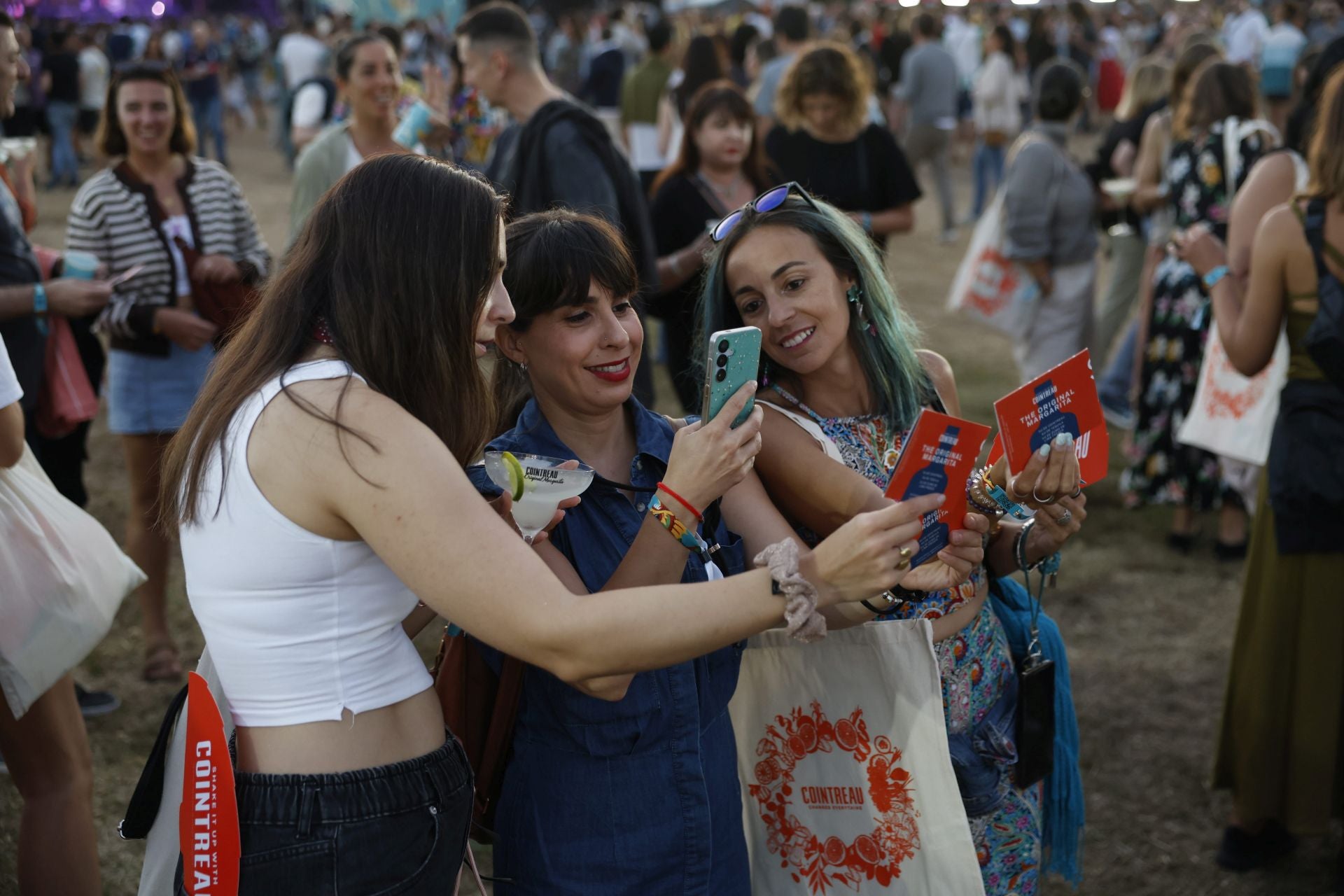 Tres jóvenes haciendo fotos durante el festival. 