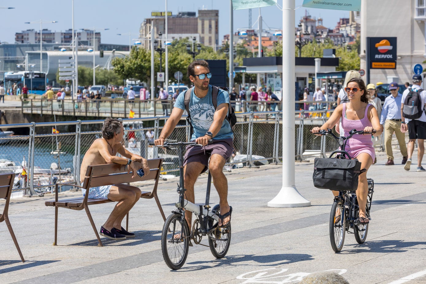 Una pareja de ciclistas pasea junto a la bahía.