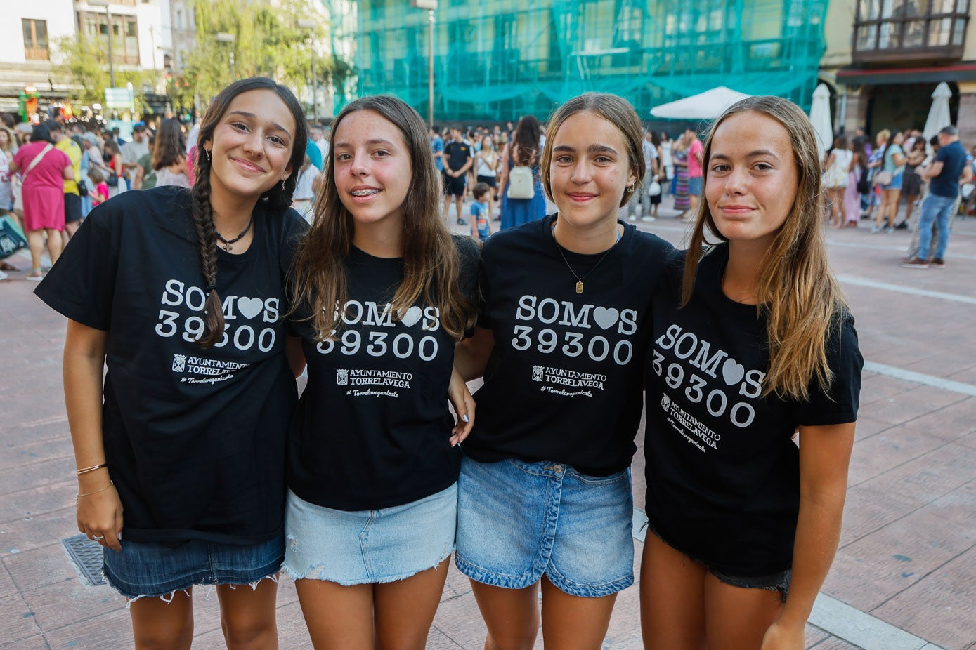Cuatro jóvenes lucen sus camisetas negras.