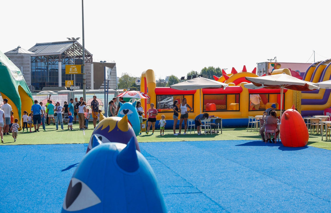 Padres y niños descansando en la zona de sombrillas del recinto.