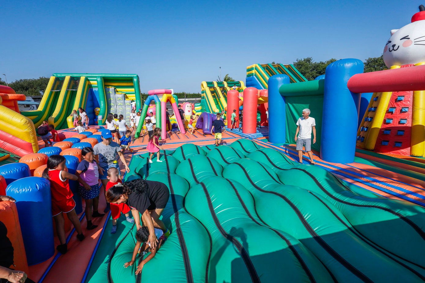 Padres e hijos se lanzan a la zona de obstáculos hinchables