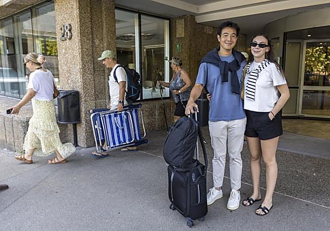Wei Yang y Alba García, con su equipaje en la puerta del Hotel Santemar.