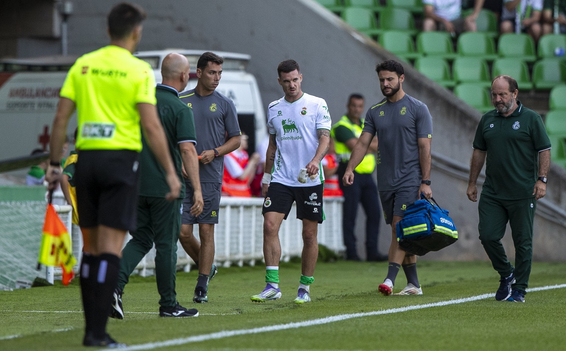 Clément Michelin, en el centro, se retira del campo acompañado por los servicios médicos.