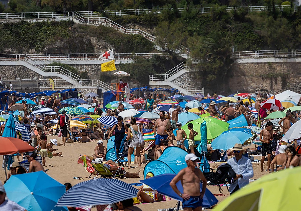 Playa de El Sardinero abarrotada, con los Jardines de Piquío de fondo.