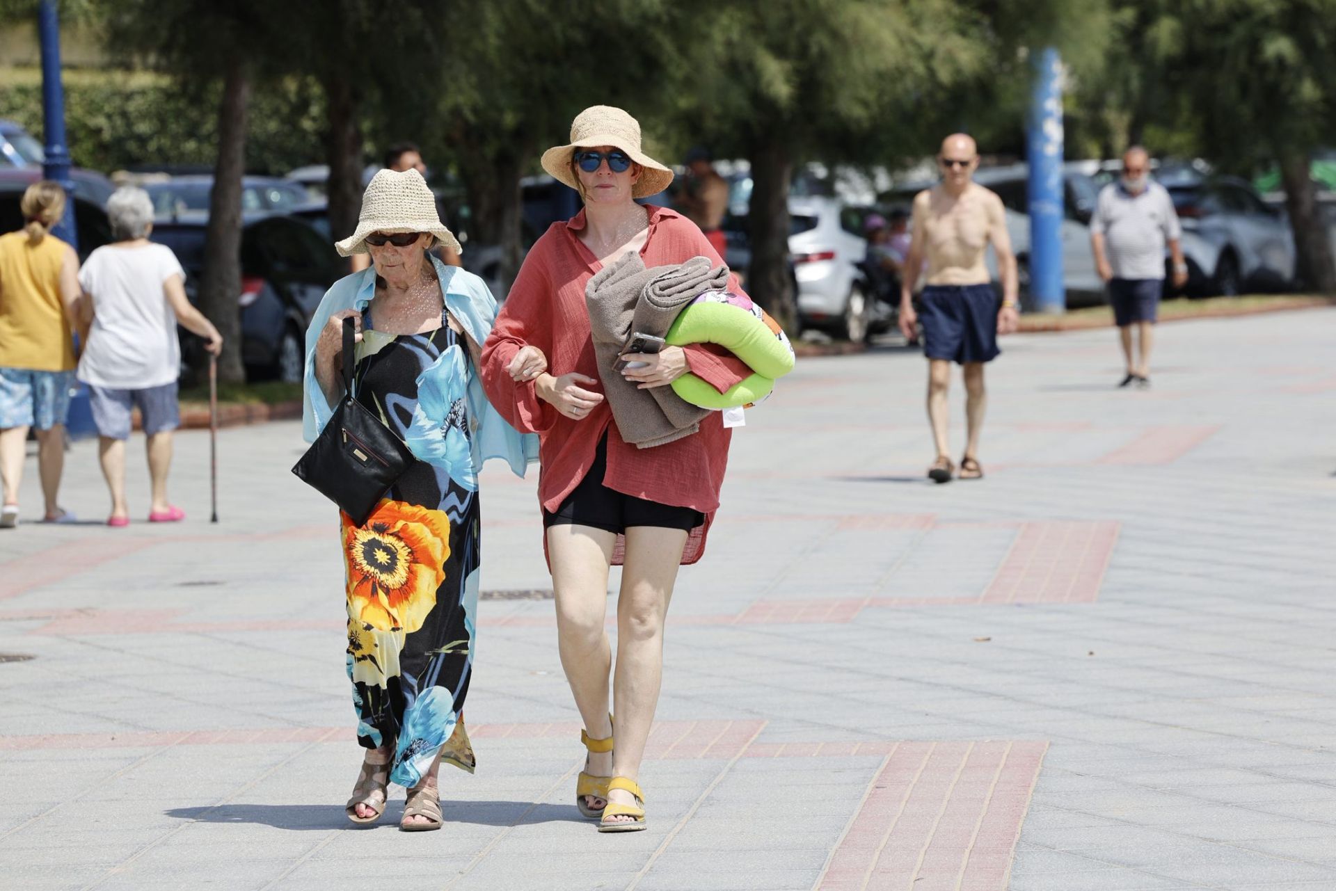 Dos mujeres pasean toalla y almohada en mano