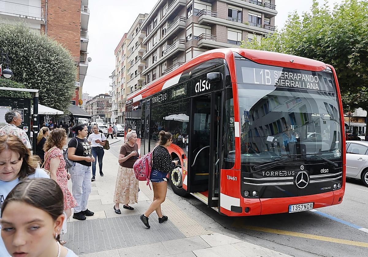 Vecinos se suben al nuevo Torrebús eléctrico, el primero en sumarse a la flota tras la renovación del servicio, ayer, en Torrelavega.