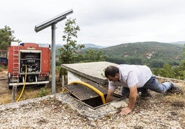 El operario de un camión cisterna abastece de agua a un depósito de Valderredible.