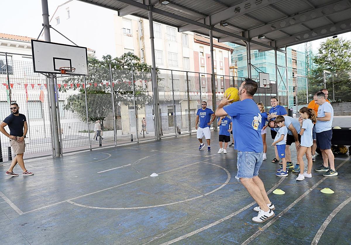 Un peñista tira el balón a canasta.