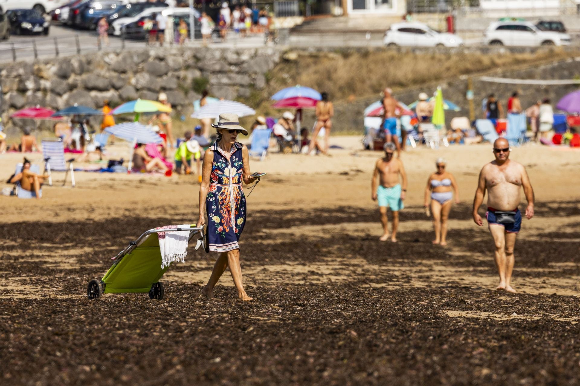 Una bañista camina sobre las algas en Trengandín.