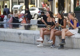 Unas jóvenes tomando un helado frente a la catedral de Santander durante otra ola de calor