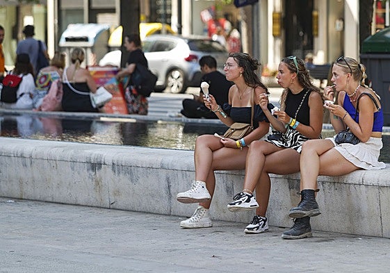 Unas jóvenes tomando un helado frente a la catedral de Santander durante otra ola de calor
