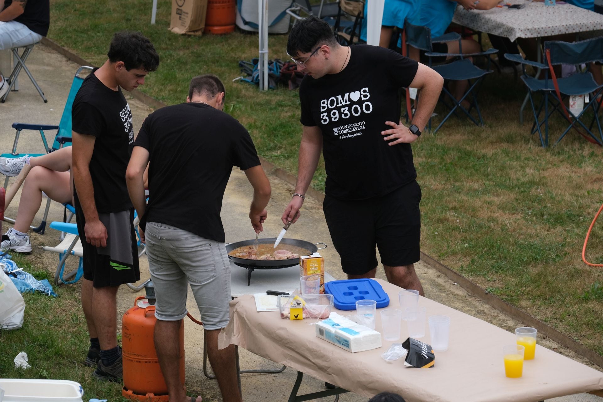 Participantes remueven el arroz luciendo camisetas de «Somos 39300»