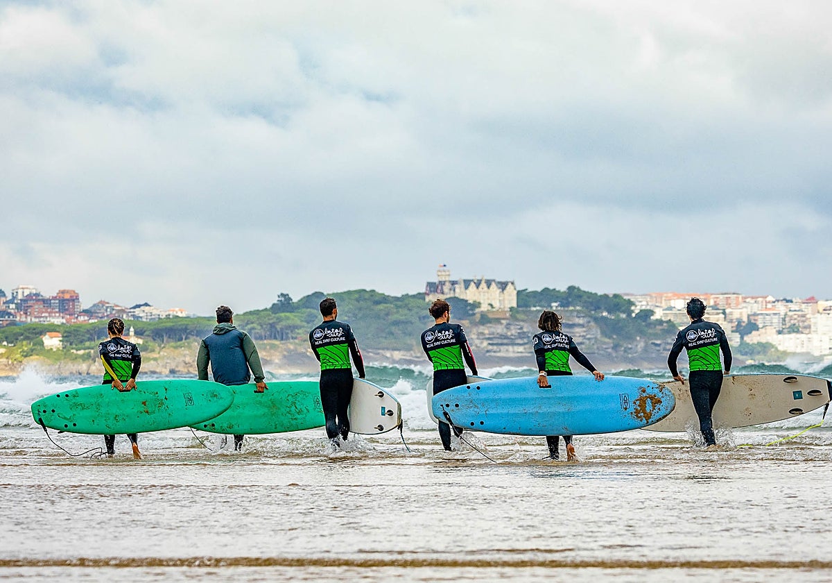 Alumnos de una escuela de surf en Somo a punto de entrar al agua.