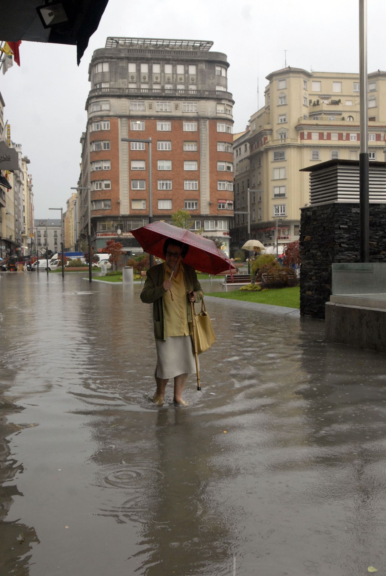 Una mujer camina por la plaza del Ayuntamiento completamente anegada de agua tras la remodelación en 2001