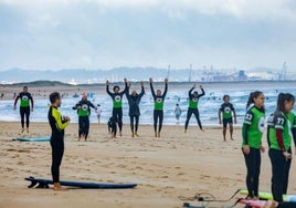 Alumnos de una escuela de surf en Somo a punto de entrar al agua.