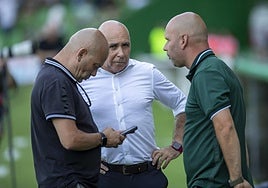 Chema Aragón ojea su móvil mientras conversa con Manolo Higuera y José Alberto López en los Campos de Sport.