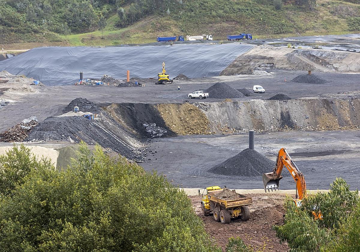 Una pala trabaja, en primer término en la fotografía, en la zona en que se construirá el segundo vaso de depósito.
