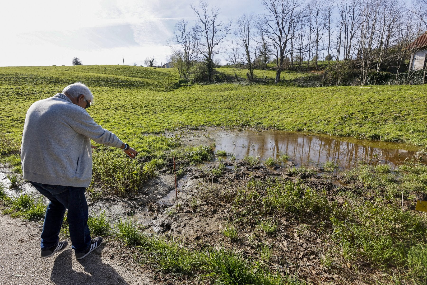 Un vecino del barrio, Bonifacio Sañudo, señala una zona que se inunda frecuentemente.