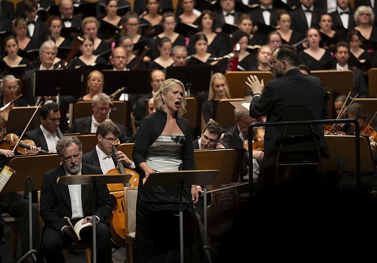 Andris Nelsons, junto a la sopranoJulia Kleiter y el barítono Christian Gerhaher, dirige a la orquesta germana el pasado domingo. Al fondo, los integrantes del Orfeón Donostiarra.