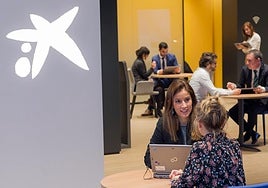 Clientes y trabajadores en una oficina de Caixa.