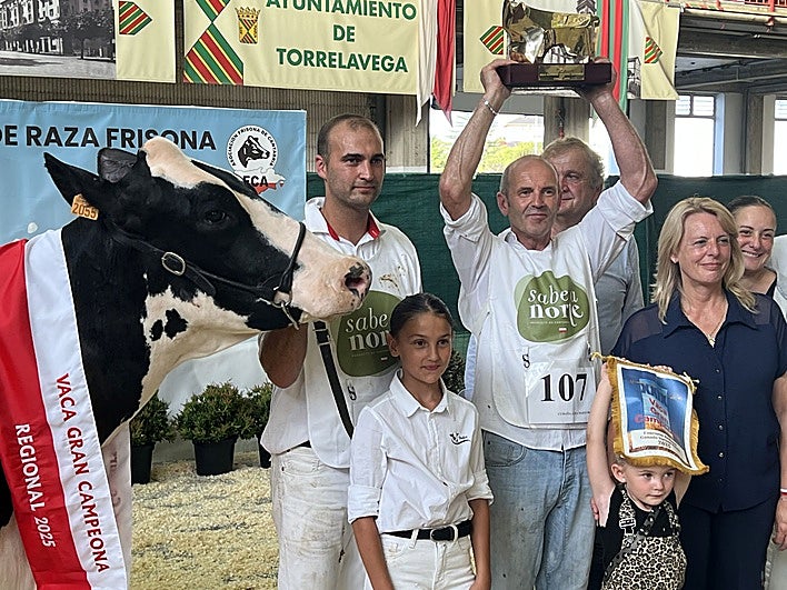 Fotografía: Adrián e Ivón Entrecanales, con sus hijas, la consejera María Jesús Susinos, y el alcalde de Valdáliga, Lorenzo González, posan con el trofeo de 'Vaca Gran Campeona' al que se hizo acredora Cudaña Arenetes Dallas| Vídeo: Ivón Entrecanales, de Ganadería Cudaña, la ganadora.