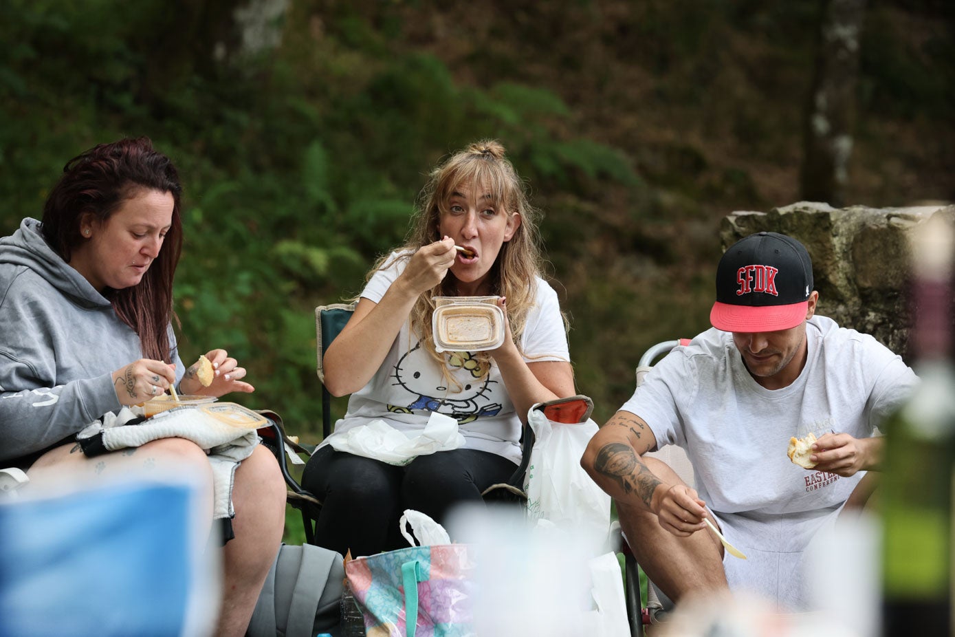 Un grupo de amigos degusta el cocido en la campa