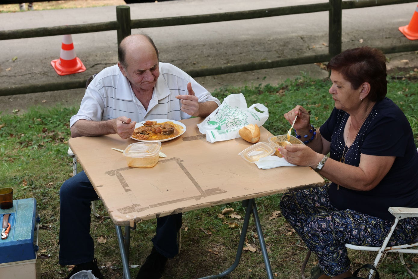 Un matrimonio degusta la comida en la campa.