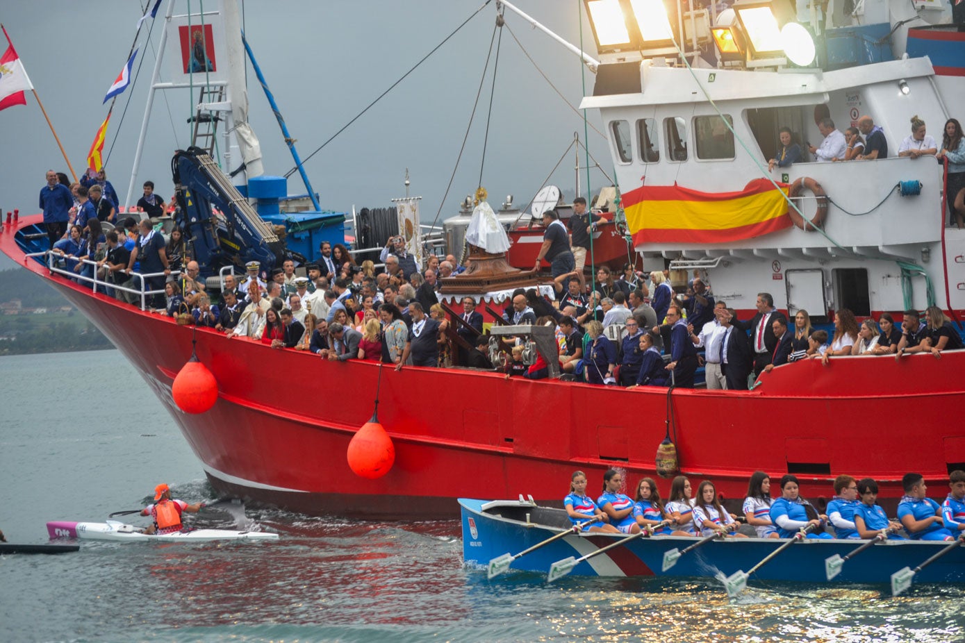 La multitud, a bordo del Nuevo Libe, encargado de llevar a bordo a la imagen, junto a los remeros. 