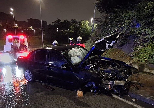 Los bomberos de Santander asisten al vehículo impactado contra un talud y una farola, en la S-20.