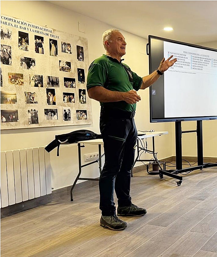 Imagen secundaria 2 - El salón de usos múltiples lleno de público para escuchar la conferencia; comida de hermandad de vecinos de Tresviso con los espeleólogos de la Universidad de Lancaster, y Fernando Rivero, capitán del Greim de Jaca durante su intervención