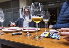 Unos clientes toman unas cañas y fuman en la terraza de un bar.