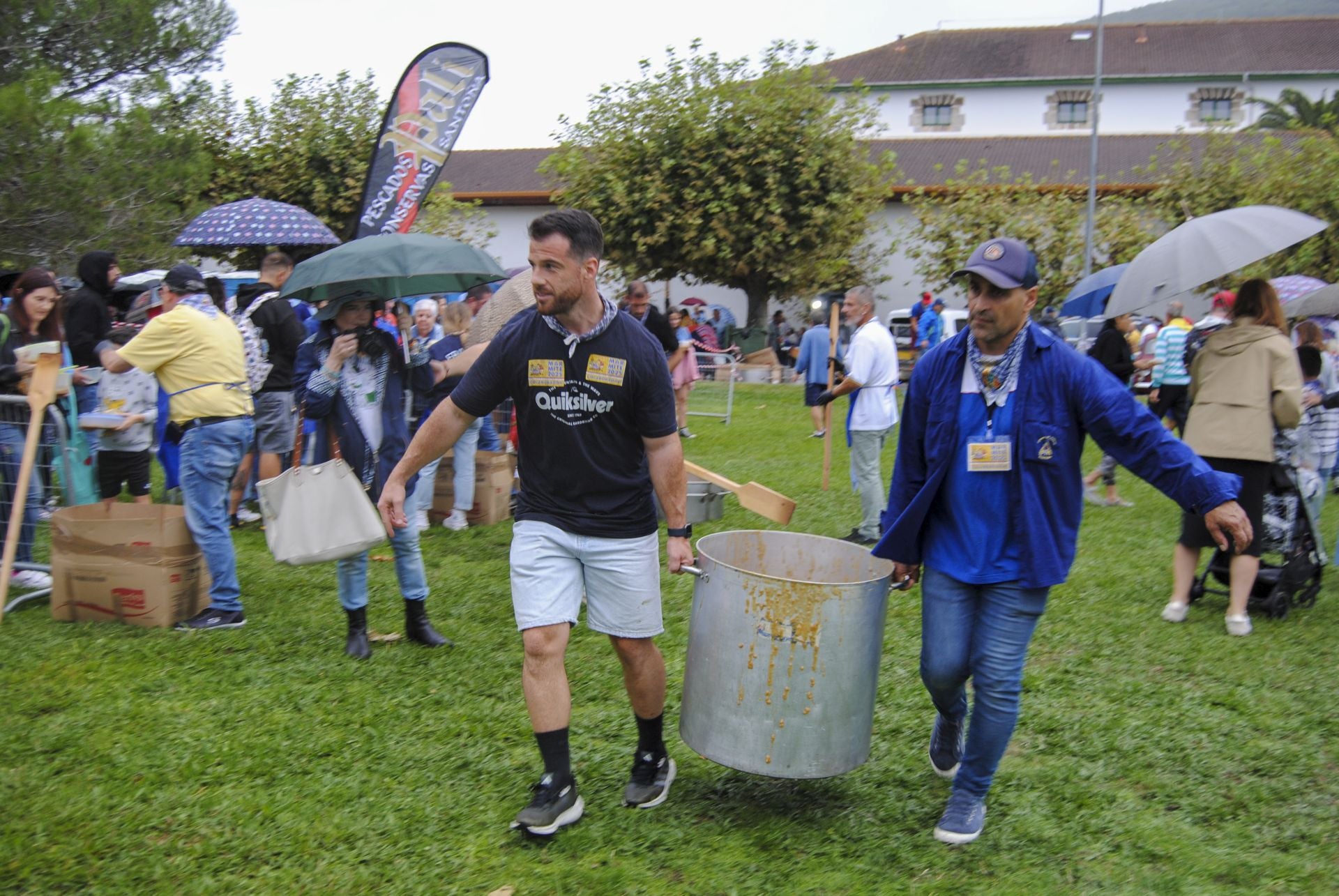 Voluntarios de murgas y peñas reponen las enormes cazuelas con marmite cocinado durante la mañana. 