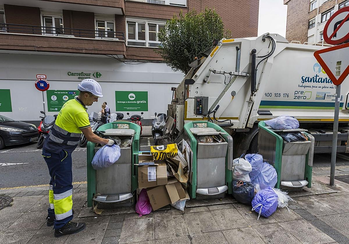 Uno de los trabajadores de la empresa PreZero, adjudicataria del servicio de emergencia, ayer, recoge la basura de los contenedores neumáticos de la calle Castilla Hermida.