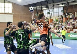 Oswaldo Maestro, lateral derecho del Bathco, salta mientras arma el brazo para el disparo rodeado de rivales del Rebi Cuenca.