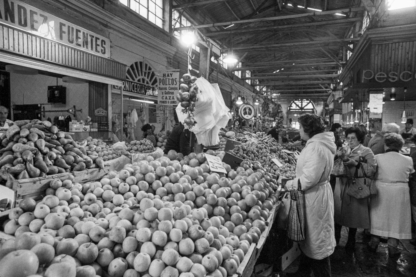 Varias mujeres esperan su turno en uno de los puestos de frutería que había en el Mercado. 