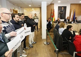 Policías locales se concentran con pancartas durante la celebración de un pleno en Torrelavega.