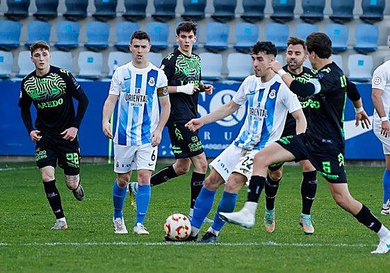 Santamaría, con el balón, rodeado de jugadores del Laredo.