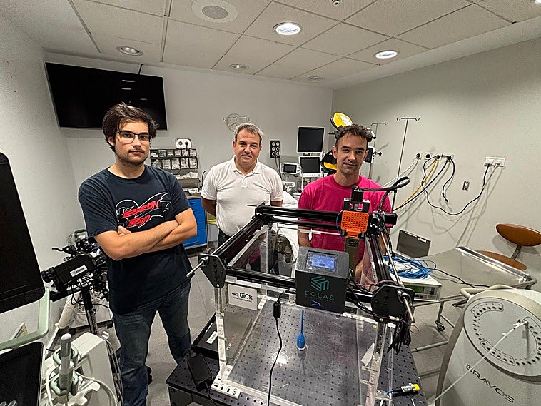 Diego Rosich, Iván Vila y Alberto Arteche, en Valdecilla, con el cubo de agua que simula un cuerpo humano para probar su instrumental.