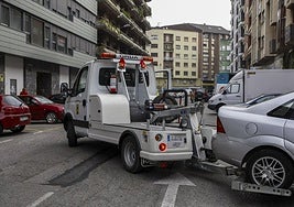 Una grua municipal retira un vehículo mal estacionado en Torrelavega.