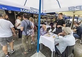 Un camarero atiende a unos clientes en una terraza del Barrio Pesquero, en Santander.