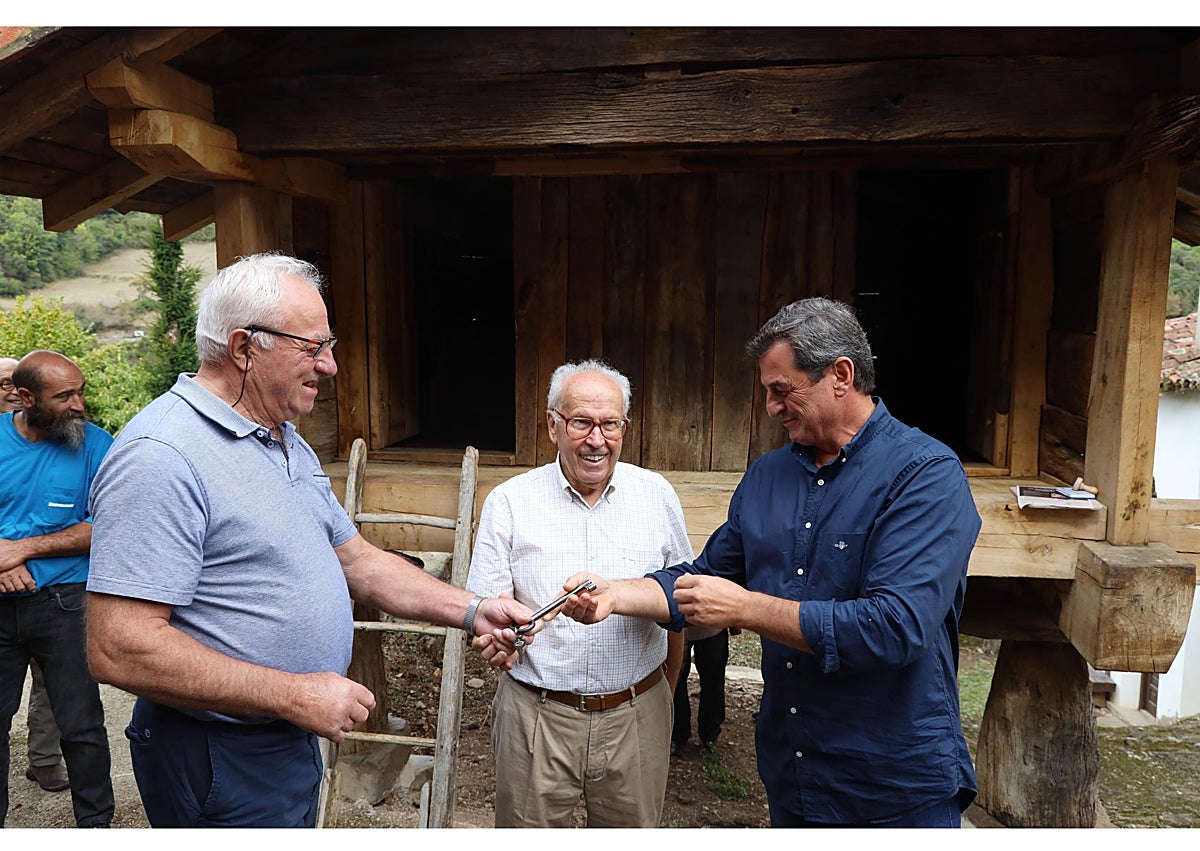 Imagen secundaria 1 - Los propietarios del hórreo recibieron una maqueta en relieve; entrega de la llave del hórreo por parte de los propietarios al alcalde, Enrique Sabarís, y el alcalde entregando sellada la credencial del Camino Lebaniego a dos vecinas