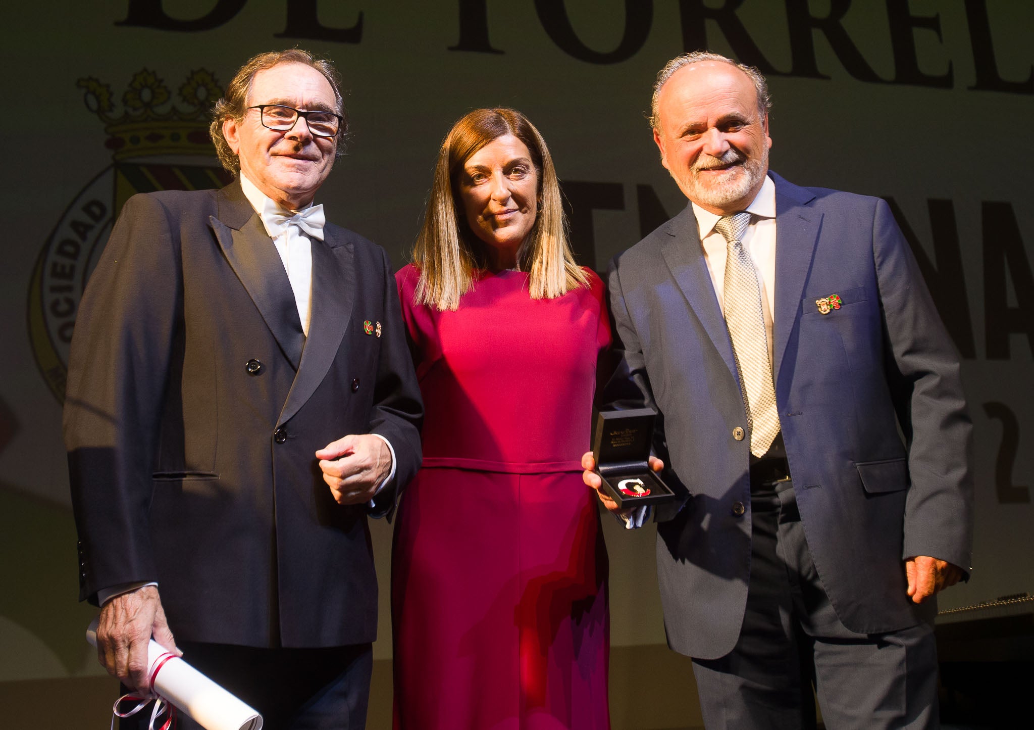 La presidenta de Cantabria posa junto a el presidente y el director musical de la Coral tras entregarles el premio 'C' de cultura.