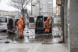 Trabajadores del servicio de limpieza de Camargo limpiando el suelo de una calle.