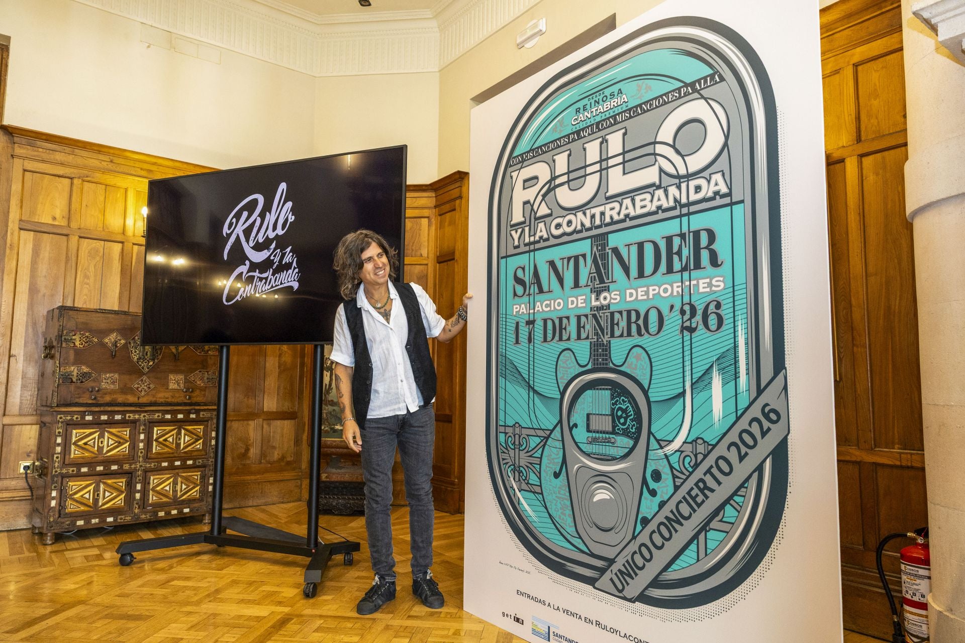 Rulo contempla sonriente el cartel que anuncia su cita en la capital cántabra.