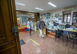 Asun Arabaolaza, con la vicepresidenta de la asociación de vecinos, Virginia Pérez, recogiendo el pasado febrero la biblioteca, tras su cierre.