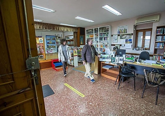 Asun Arabaolaza, con la vicepresidenta de la asociación de vecinos, Virginia Pérez, recogiendo el pasado febrero la biblioteca, tras su cierre.