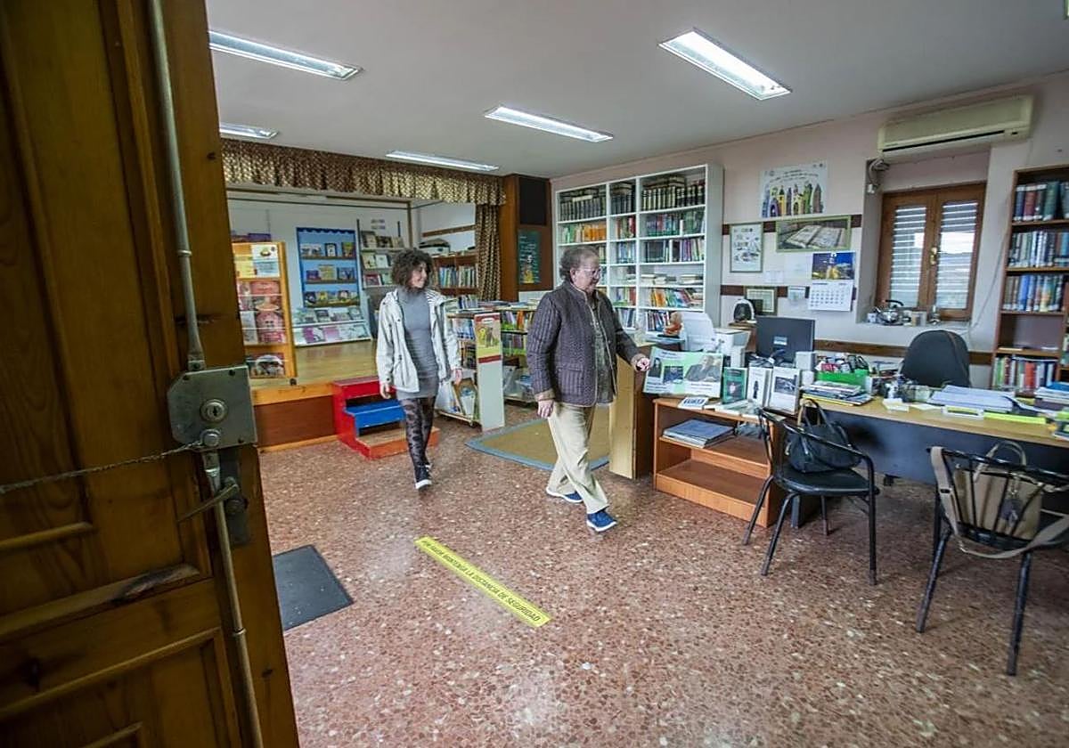 Asun Arabaolaza, con la vicepresidenta de la asociación de vecinos, Virginia Pérez, recogiendo el pasado febrero la biblioteca, tras su cierre.