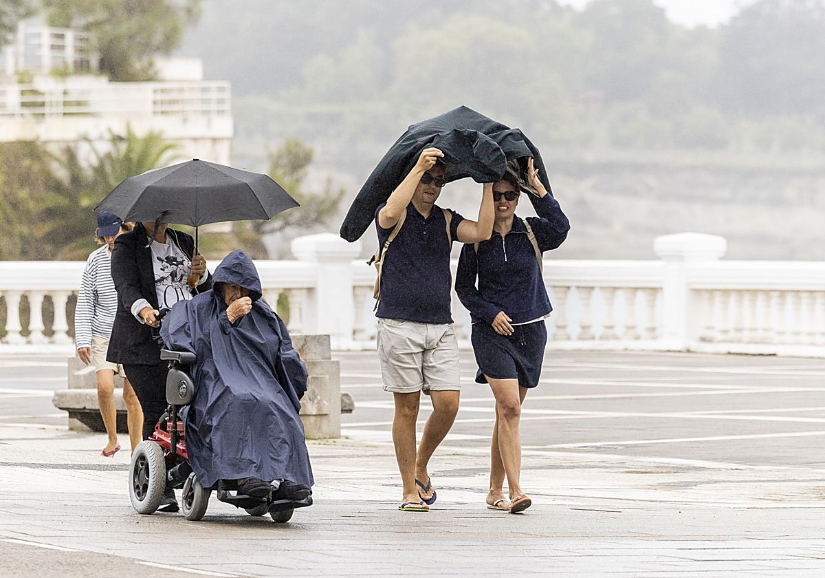 Turistas bajo la lluvia en la zona de El Sardinero, en Santander, el pasado septiembre.