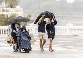 Turistas bajo la lluvia en la zona de El Sardinero, en Santander, el pasado septiembre.